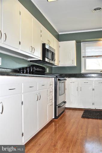 779 Masons Beach Road Deale, MD 20751 - Photo 6 of 14 a kitchen with granite countertop a stove a sink and a microwave