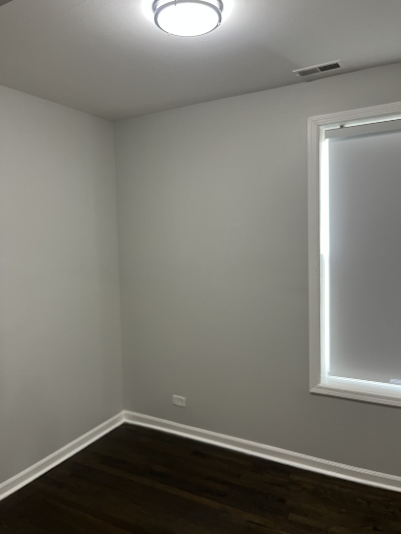1249 South Kolin Avenue, Unit 1 Chicago, IL 60623 - Photo 14 of 20 a room with a window and wooden floor