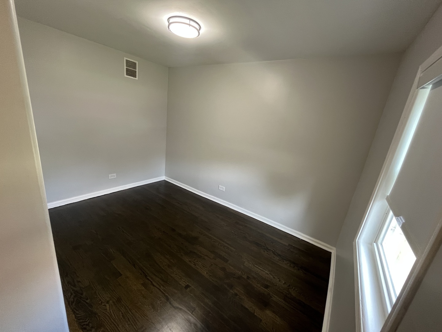 1249 South Kolin Avenue, Unit 1 Chicago, IL 60623 - Photo 20 of 20 en empty room with wooden floor and windows
