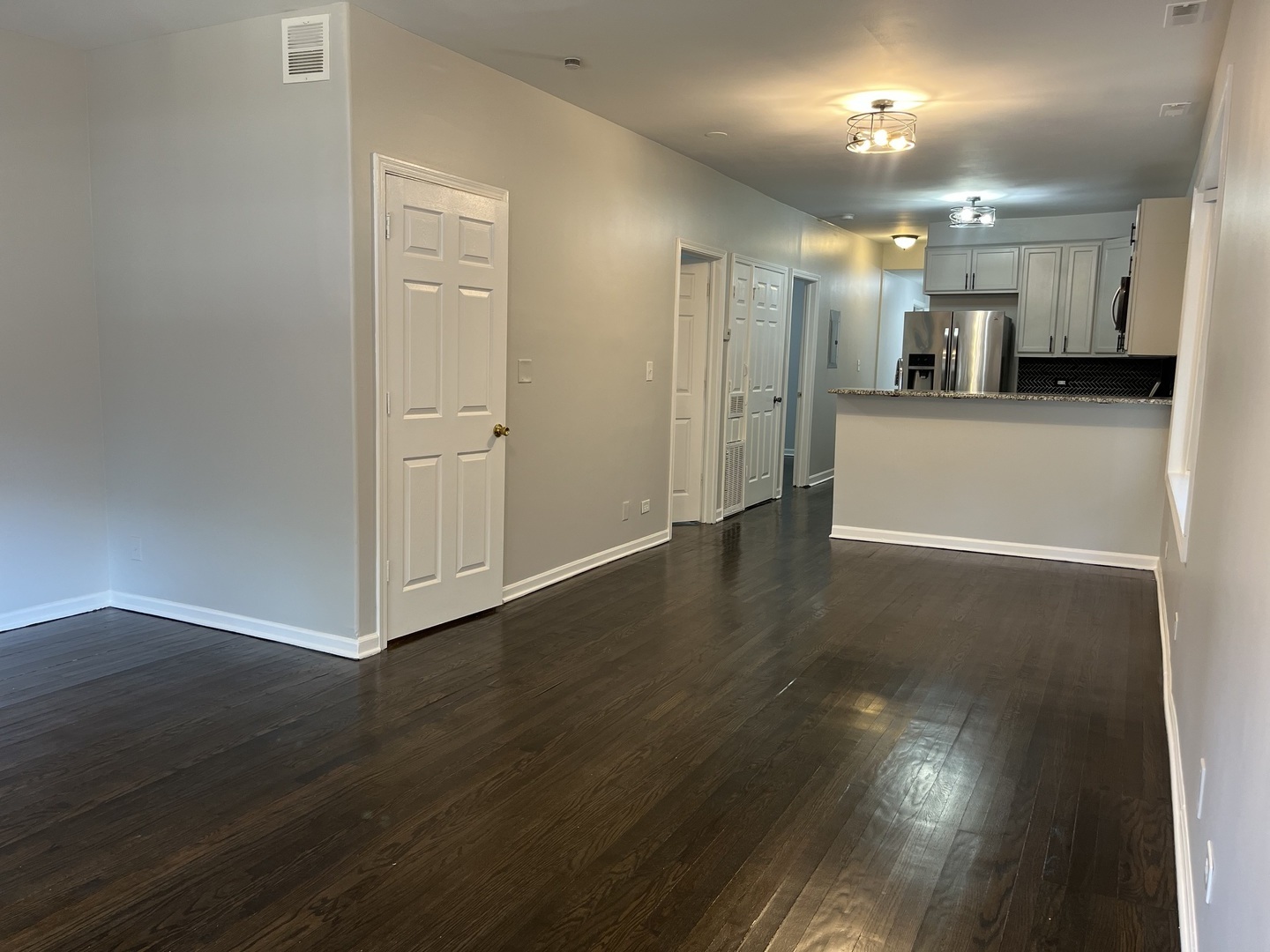 1249 South Kolin Avenue, Unit 1 Chicago, IL 60623 - Photo 4 of 20 a view of a big room with wooden floor and a kitchen