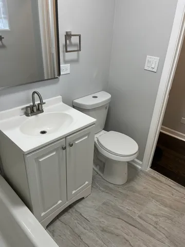 a bathroom with a toilet sink and mirror