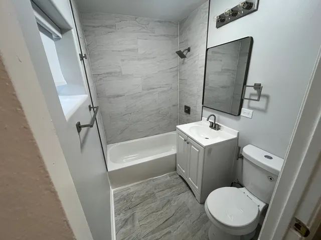 a white toilet sitting next to a bath tub