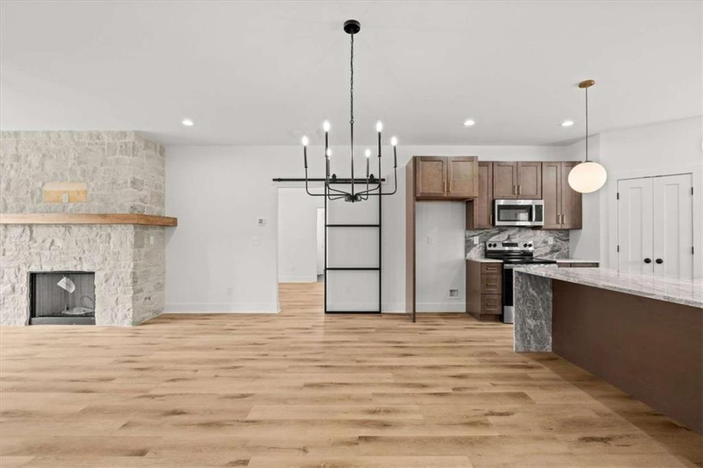 415 Lively Road Waco, GA 30182 - Photo 12 of 49 a kitchen with stainless steel appliances granite countertop a refrigerator a stove a sink dishwasher and a fireplace with wooden floor