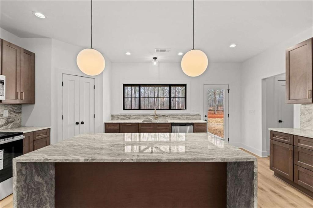 415 Lively Road Waco, GA 30182 - Photo 13 of 49 a kitchen with kitchen island granite countertop a stove a sink and a refrigerator
