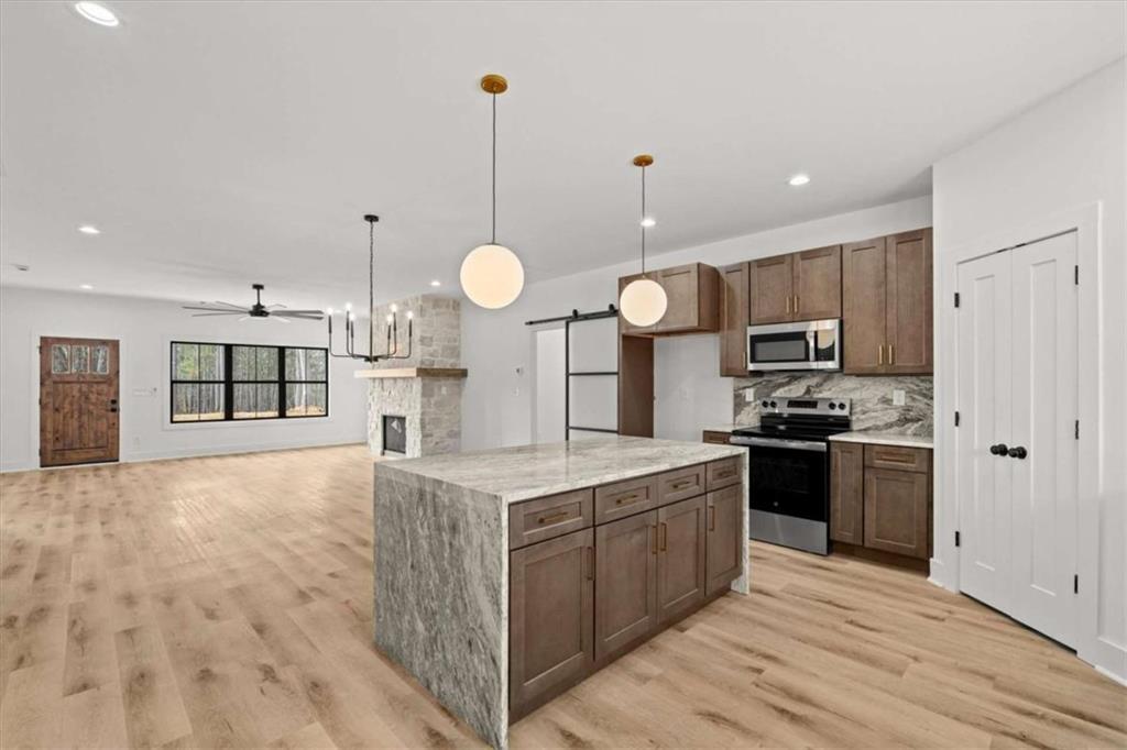 415 Lively Road Waco, GA 30182 - Photo 16 of 49 a large kitchen with stainless steel appliances kitchen island granite countertop a stove a sink dishwasher and a refrigerator with wooden floor