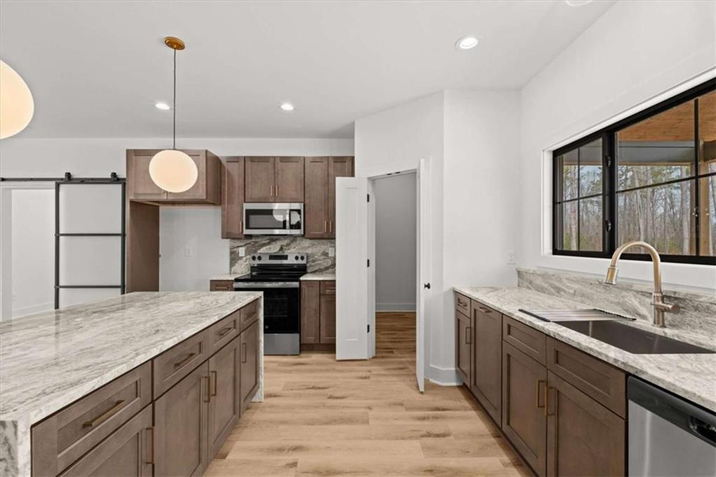 415 Lively Road Waco, GA 30182 - Photo 17 of 49 a kitchen with stainless steel appliances granite countertop a sink refrigerator and cabinets