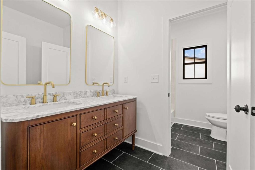 415 Lively Road Waco, GA 30182 - Photo 36 of 49 a bathroom with a granite countertop sink a toilet and a mirror