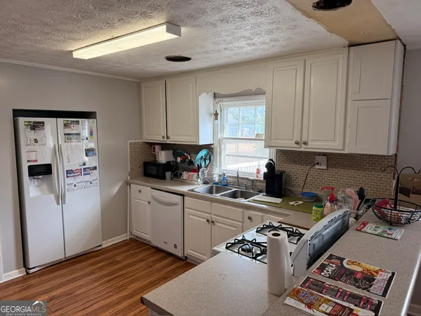 a kitchen with a refrigerator and a stove top oven