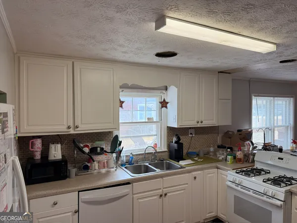 a kitchen with a sink a stove and cabinets