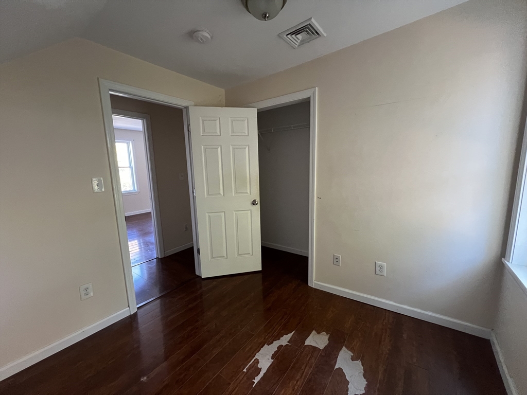 22 Forest Avenue Clinton, MA 01510 - Photo 9 of 13 an empty room with wooden floor and windows