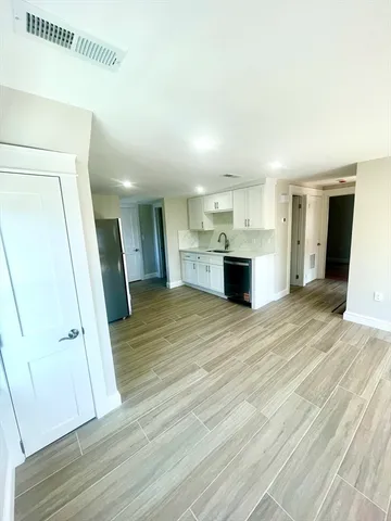 a view of a kitchen cabinets wooden floor and staircase