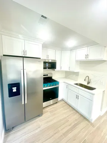 a kitchen with stainless steel appliances granite countertop a refrigerator a sink a stove a microwave and island