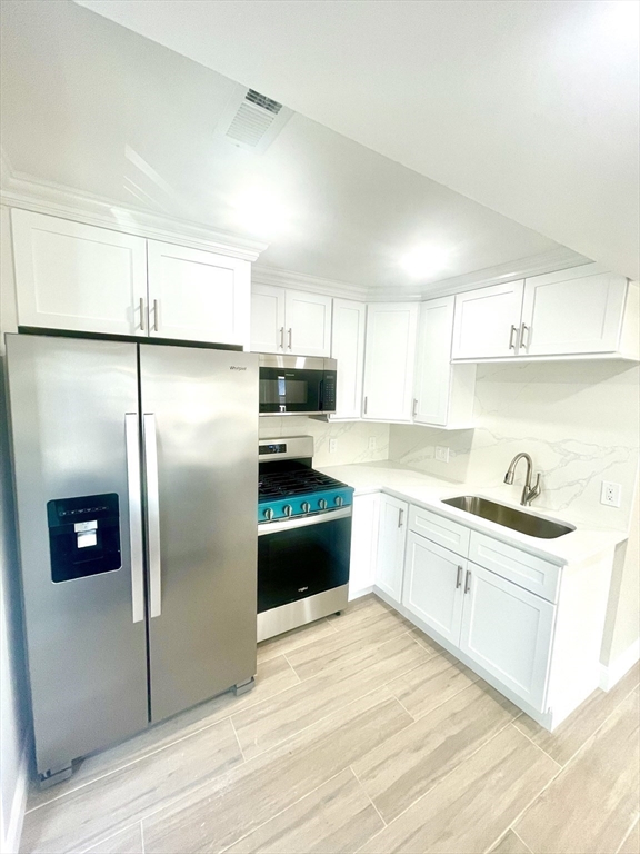 435 Newport Road, Unit 2 Hull, MA 02045 - Photo 3 of 38 a kitchen with stainless steel appliances granite countertop a refrigerator a sink a stove a microwave and island