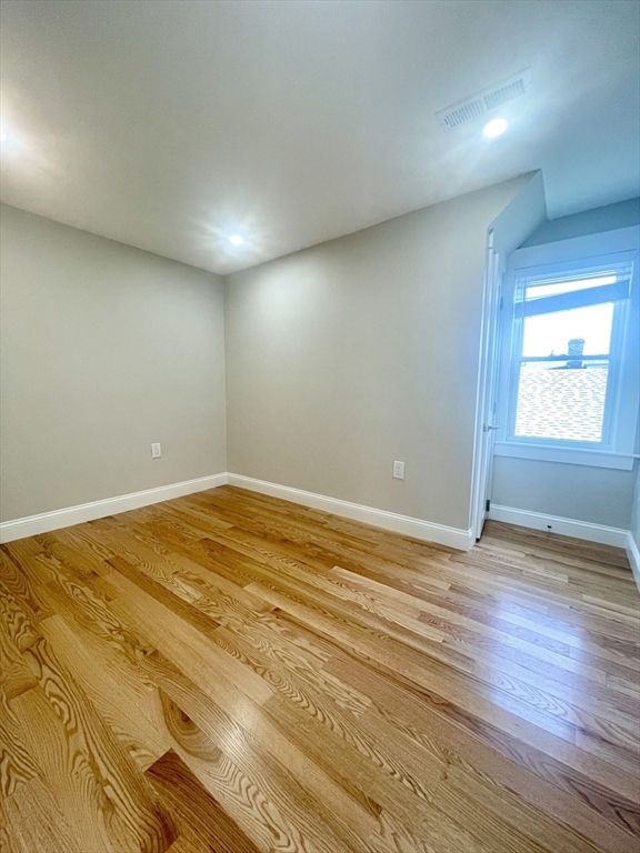 435 Newport Road, Unit 2 Hull, MA 02045 - Photo 32 of 38 an empty room with wooden floor and windows