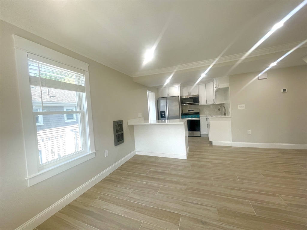 435 Newport Road, Unit 2 Hull, MA 02045 - Photo 5 of 38 a view of kitchen with kitchen island a sink wooden floor and a refrigerator