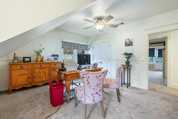a view of a white house with wooden floor and a yard