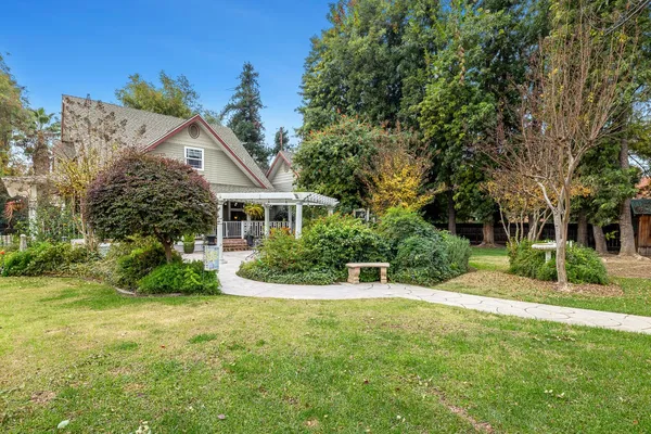 a view of a house with a yard and potted plants