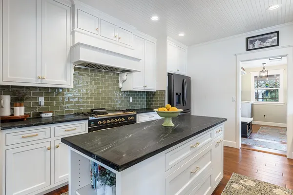 a kitchen with stainless steel appliances granite countertop a sink stove and cabinets