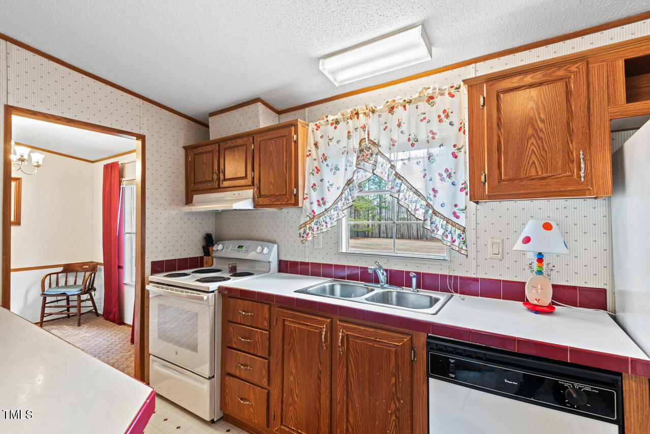 4082 Culbreth Road Stem, NC 27581 - Photo 16 of 33 a kitchen with stainless steel appliances a sink stove and cabinets