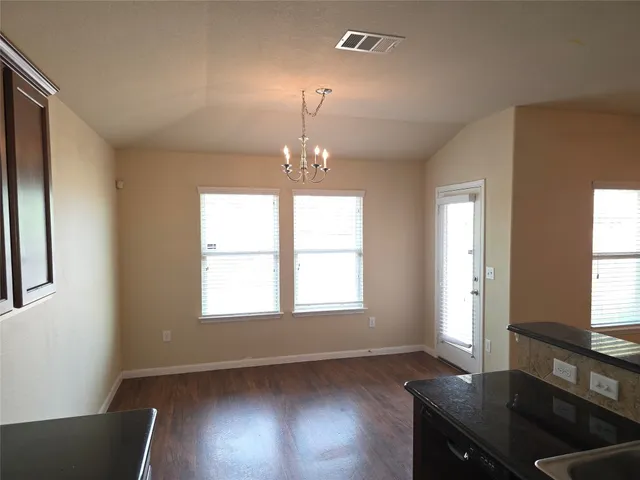 a room with wooden floor and windows