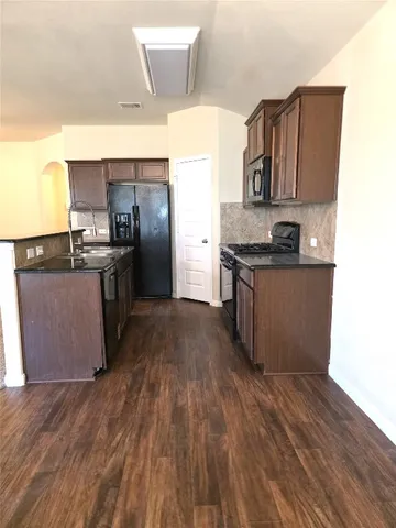 a kitchen with stainless steel appliances granite countertop a stove a sink and a refrigerator