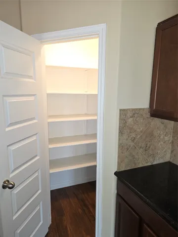 a view of walk in closet with empty racks
