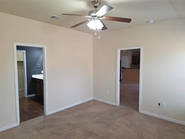an empty room with closet and a chandelier fan