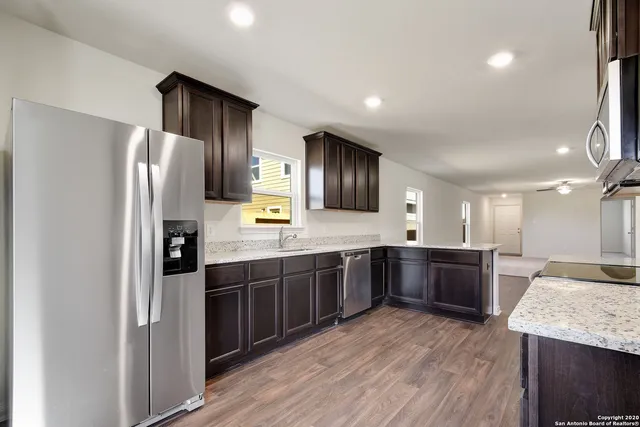 a large kitchen with a large counter top appliances and cabinets