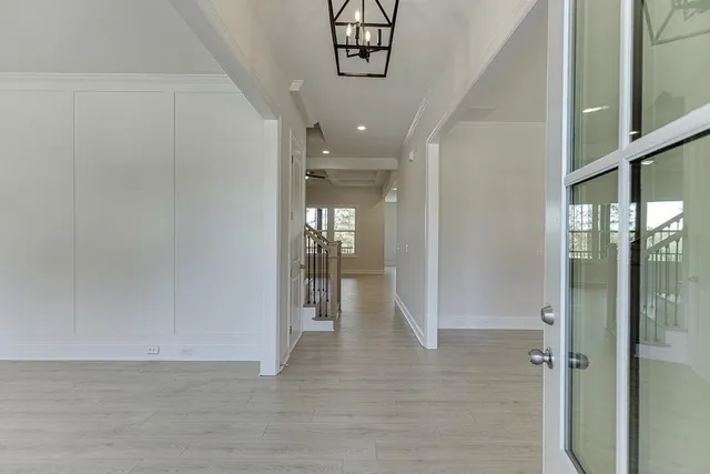 a view of a hallway with wooden floor and a living room
