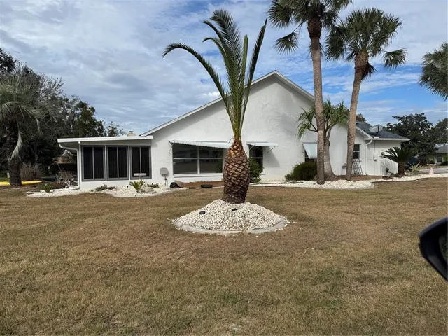 a front view of a house with garden and trees