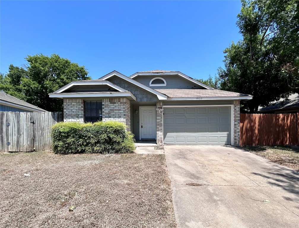 1908 Rainy Meadows Drive Austin, TX 78758 - Photo 2 of 17 a front view of a house with a yard and garage