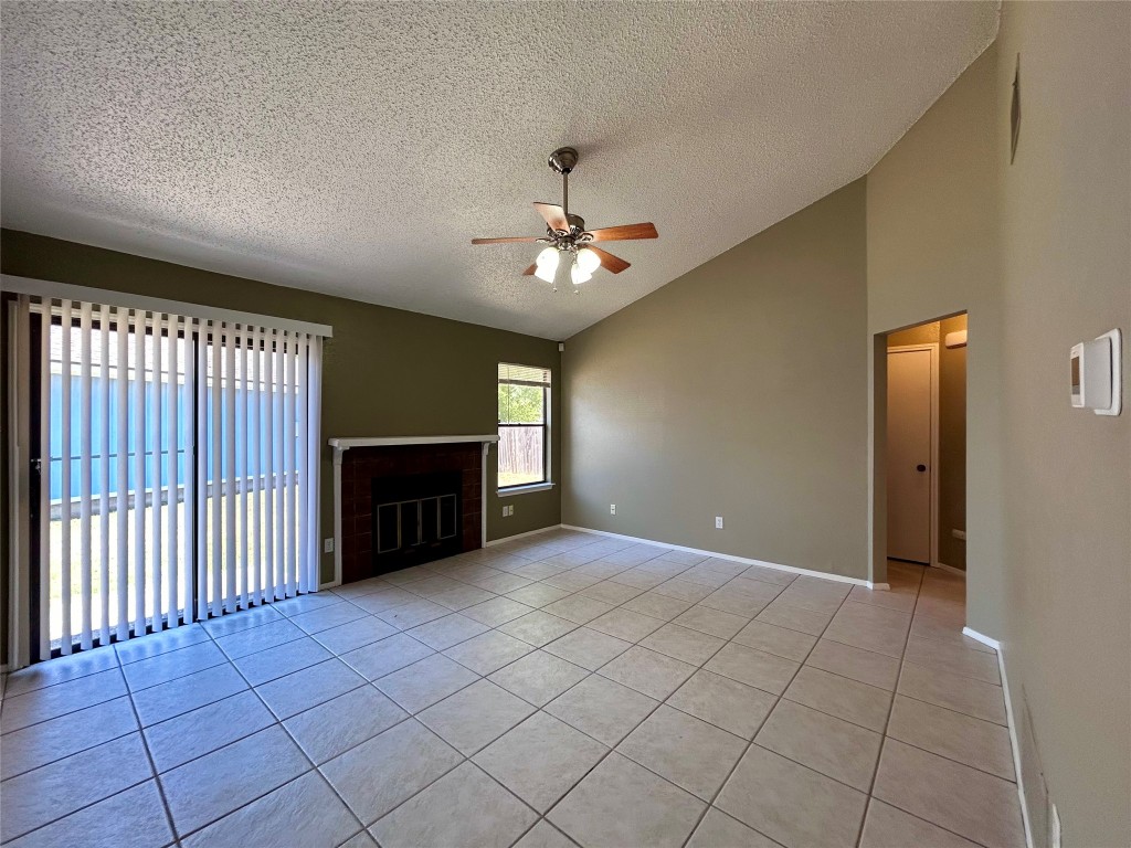 1908 Rainy Meadows Drive Austin, TX 78758 - Photo 4 of 17 an empty room with windows and fireplace
