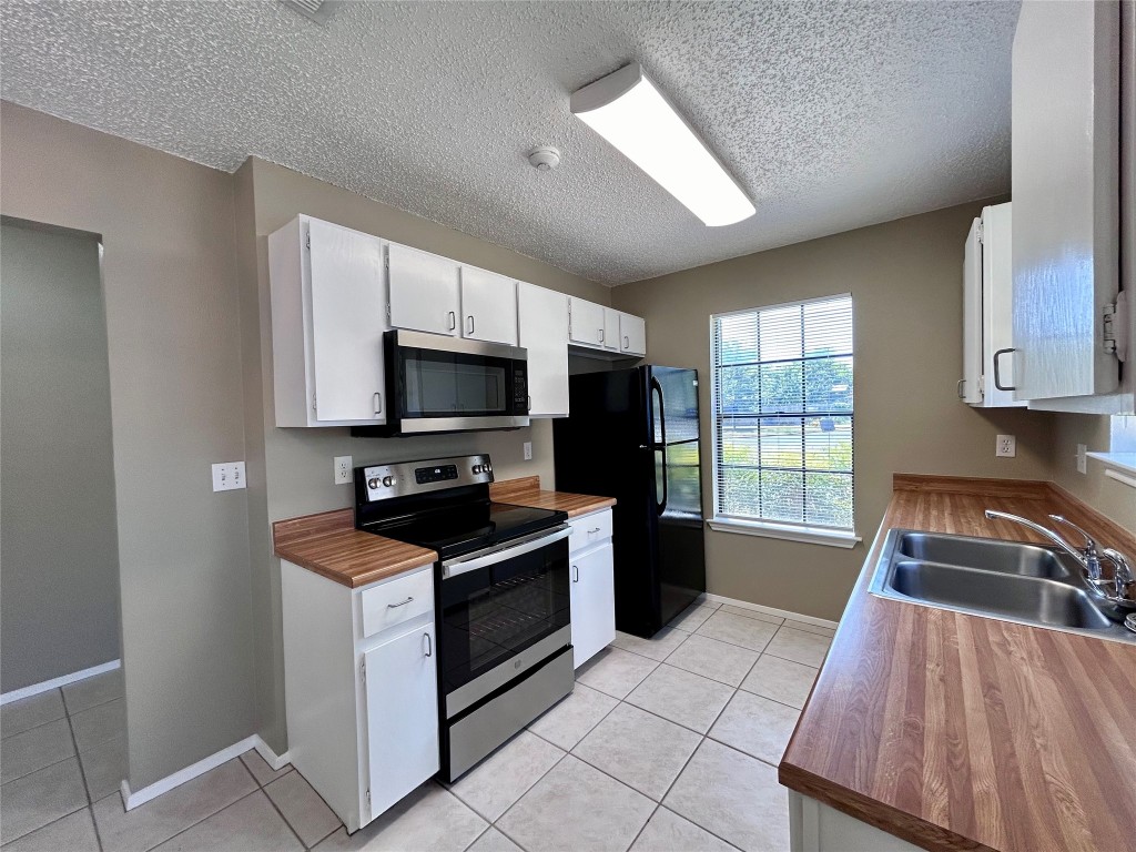 1908 Rainy Meadows Drive Austin, TX 78758 - Photo 7 of 17 a kitchen with granite countertop a stove sink and microwave
