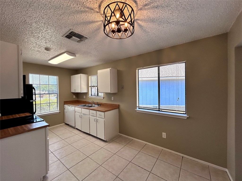 1908 Rainy Meadows Drive Austin, TX 78758 - Photo 8 of 17 a kitchen with stainless steel appliances granite countertop a stove a sink and a refrigerator