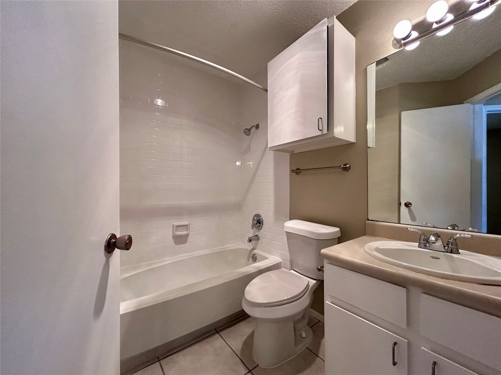 1908 Rainy Meadows Drive Austin, TX 78758 - Photo 9 of 17 a bathroom with a granite countertop sink a toilet and a bathtub