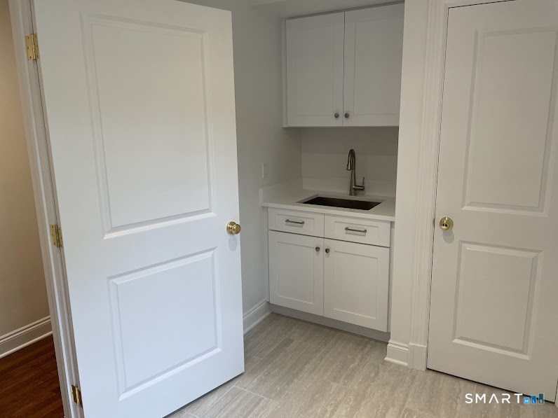 9 Tory Hole Road Darien, CT 06820 - Photo 27 of 33 a kitchen with white cabinets and white appliances