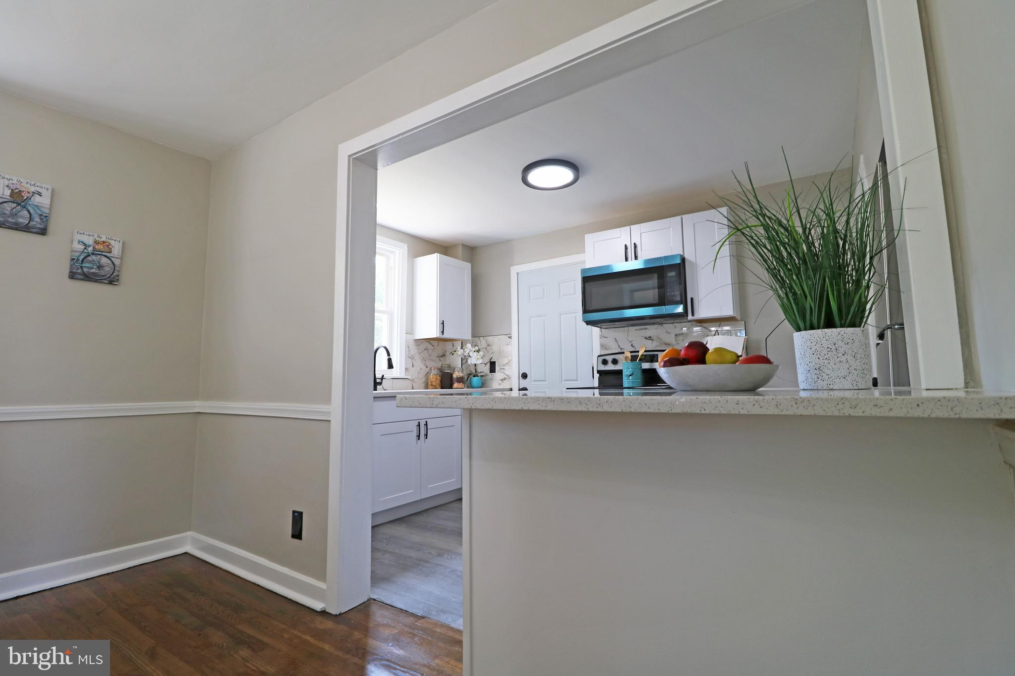 1016 Lamb Road Secane, PA 19018 - Photo 18 of 41 a kitchen with a potted plant on the counter and a wooden floor