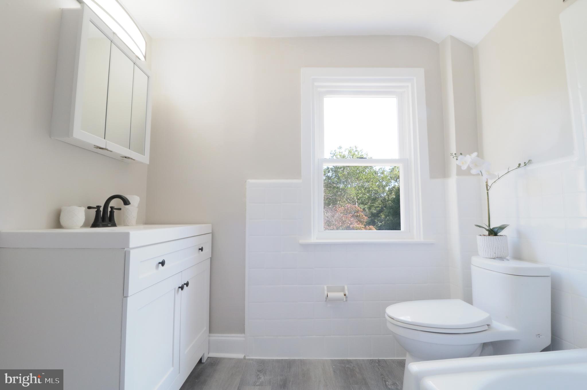 1016 Lamb Road Secane, PA 19018 - Photo 24 of 41 a bathroom with a toilet a sink a window and mirror