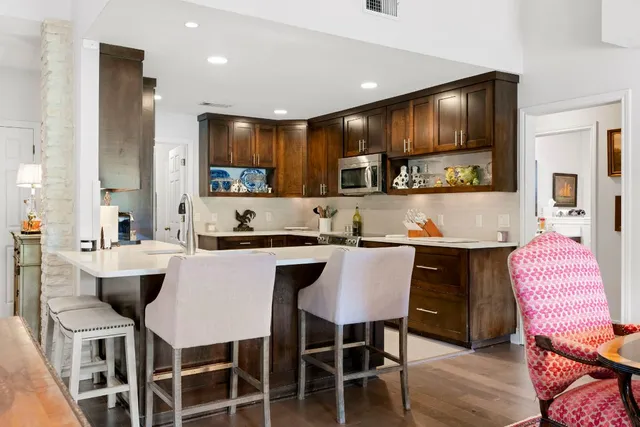 a kitchen with a dining table chairs sink and cabinets