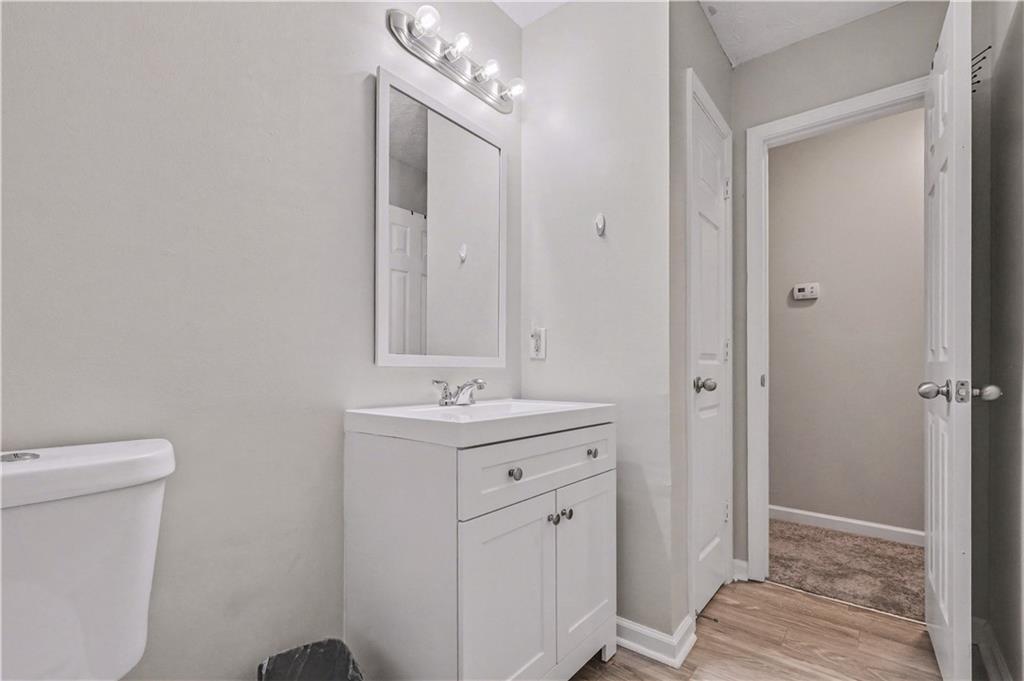 280 Courtyard Circle Winder, GA 30680 - Photo 16 of 24 a bathroom with a toilet a sink a vanity and mirror