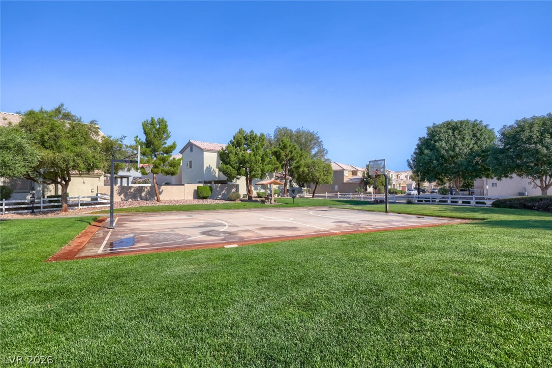 5985 High Steed Street, Unit 101 Henderson, NV 89011 - Photo 37 of 38 Green space with a paved court for recreational activities, surrounded by residential properties.