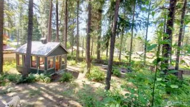 a view of a house with a street from a forest