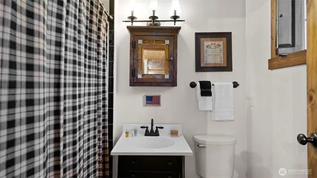 a bathroom with a sink a toilet and mirror