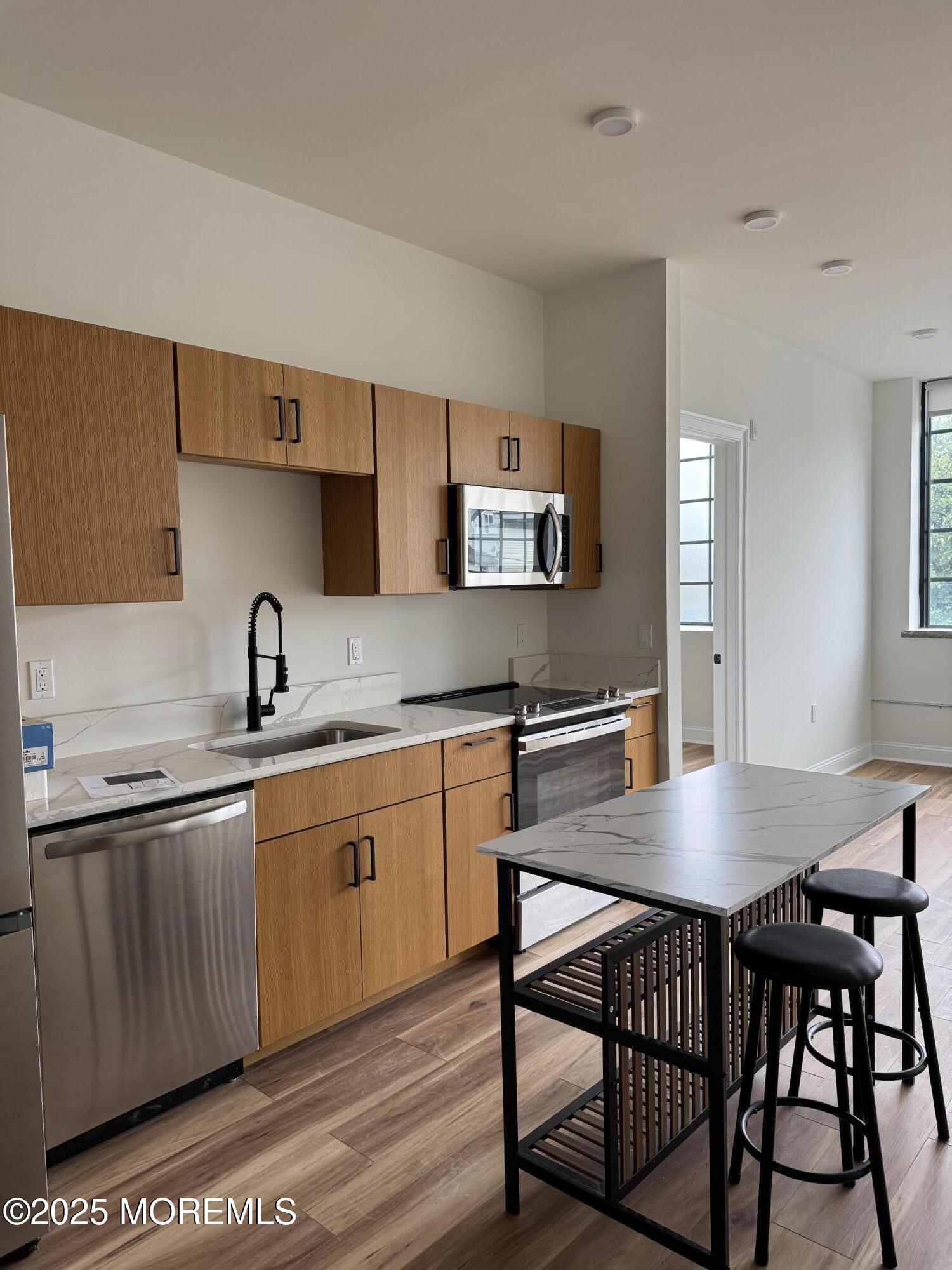 179 Chelsea Avenue, Unit 305 Long Branch, NJ 07740 - Photo 1 of 1 a kitchen with stainless steel appliances granite countertop a sink table and chairs