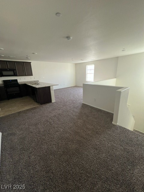 4561 Woolcomber Street Las Vegas, NV 89115 - Photo 19 of 19 Kitchen with dark colored carpet, stove, open floor plan, a peninsula, and light stone counters