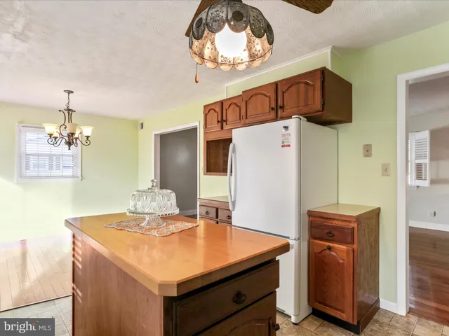 a kitchen with stainless steel appliances a stove a refrigerator and a refrigerator with wooden floor