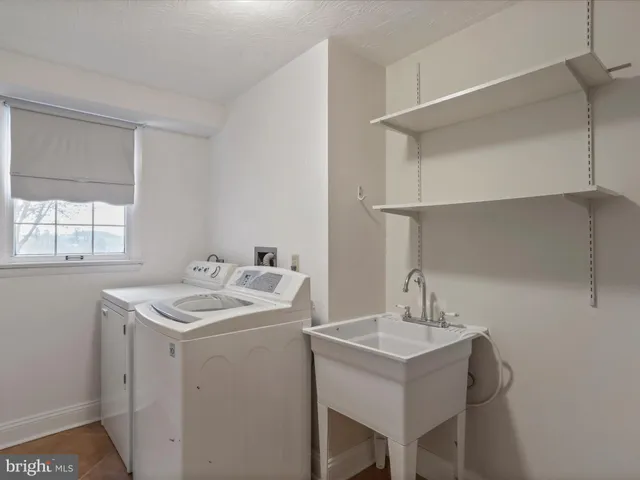 a utility room with sink dryer and washer