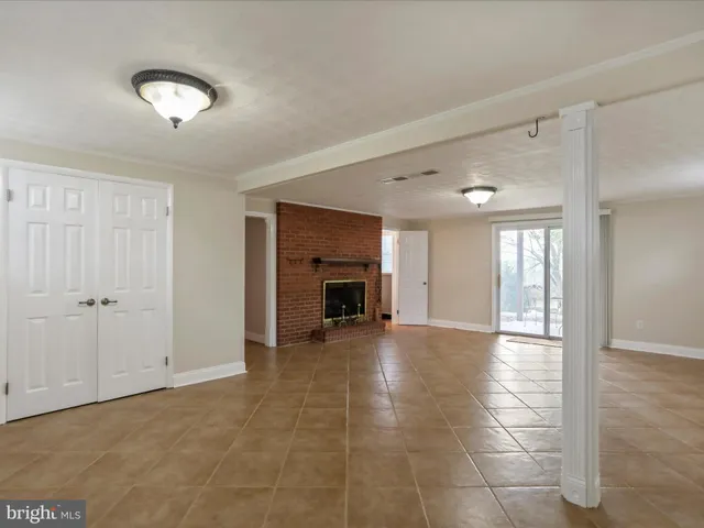 a view of an empty room with window and fire place
