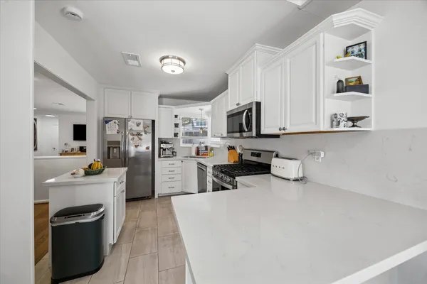 a kitchen with refrigerator a microwave and wooden cabinets