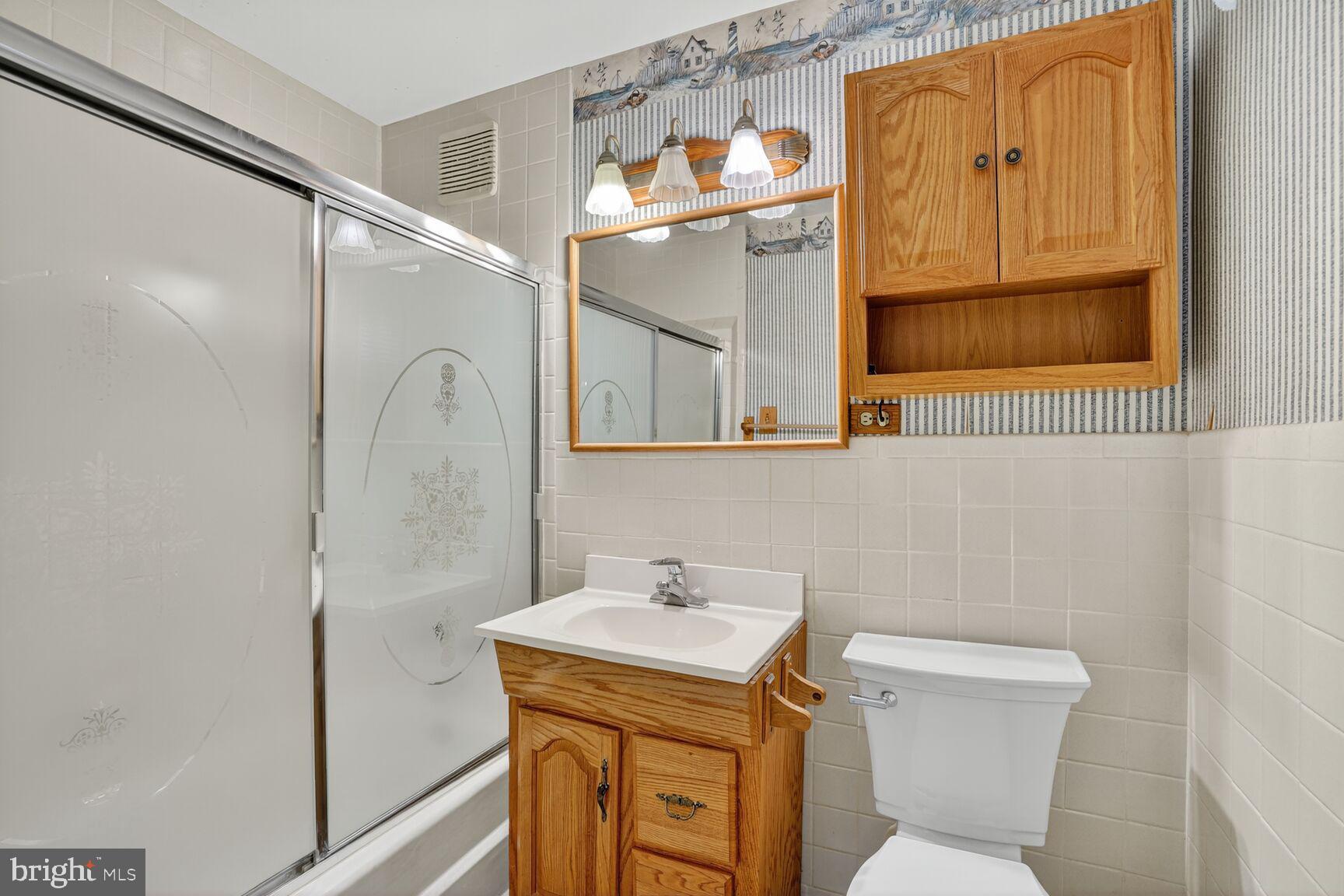 6120 Squire Lane Alexandria, VA 22310 - Photo 22 of 26 a bathroom with a sink a mirror a toilet and a shower